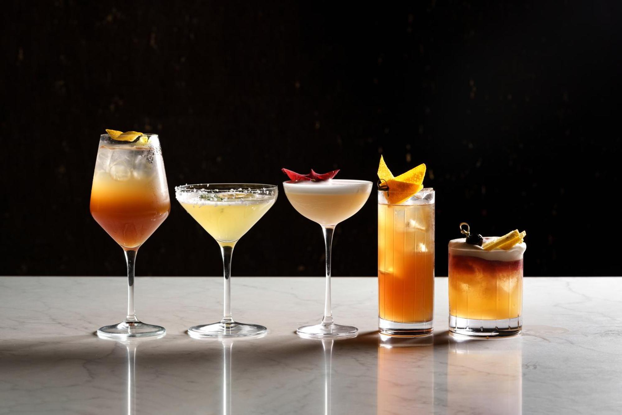 Middle Eight - Covent Garden - Preferred Hotels And Resorts London Ngoại thất bức ảnh The photo features a selection of five different cocktails lined up on a marble surface. Each drink is served in a distinct glass, showcasing a variety of colors and garnishes. 

1. The first cocktail is in a large wine glass, with a gradient color f