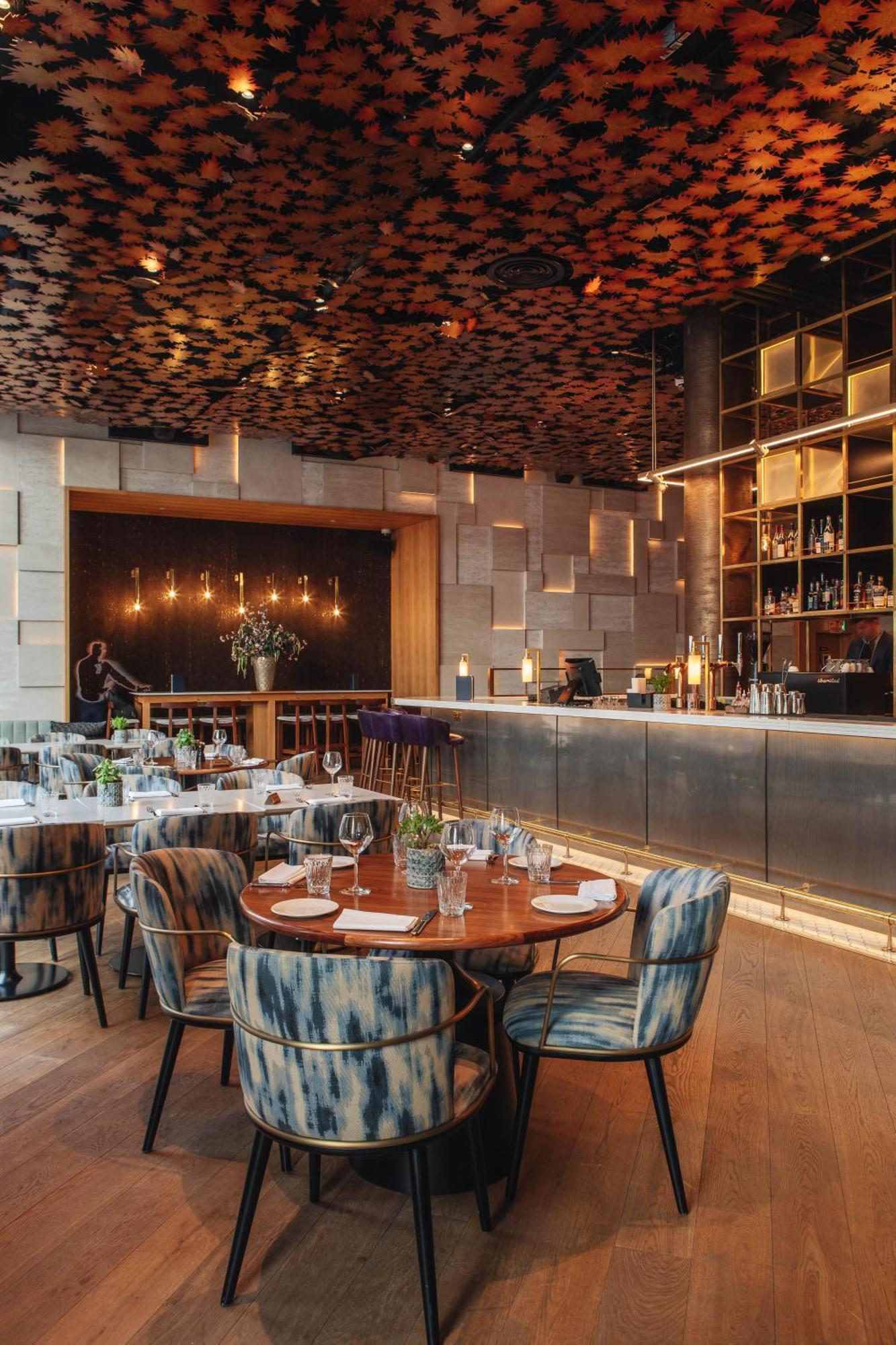 Middle Eight - Covent Garden - Preferred Hotels And Resorts London Ngoại thất bức ảnh The photo shows a stylish restaurant interior. There are round tables set with plates and glasses, surrounded by comfortable chairs. The bar area is sleek and modern, with a counter displaying various bottles. The lighting appears warm and inviting, 